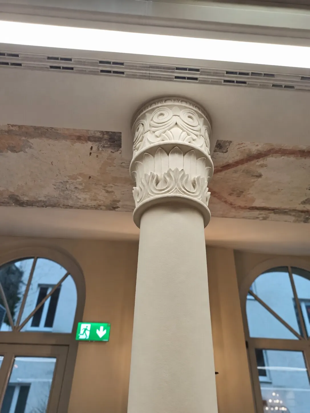 Original fragments of wall painting on the vault behind a column.