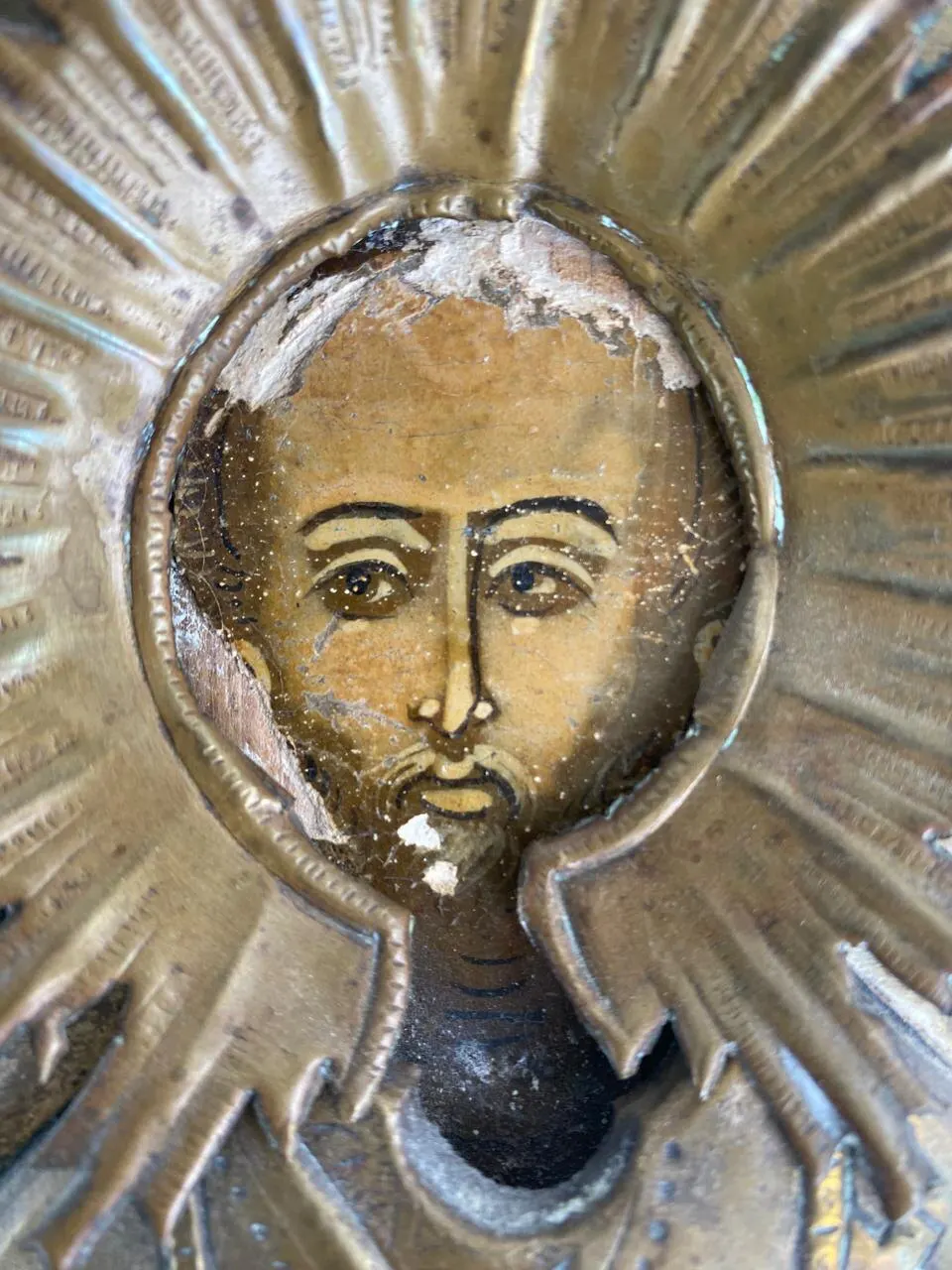 Before restoration. Detail of the face: losses of ground and paint layer.