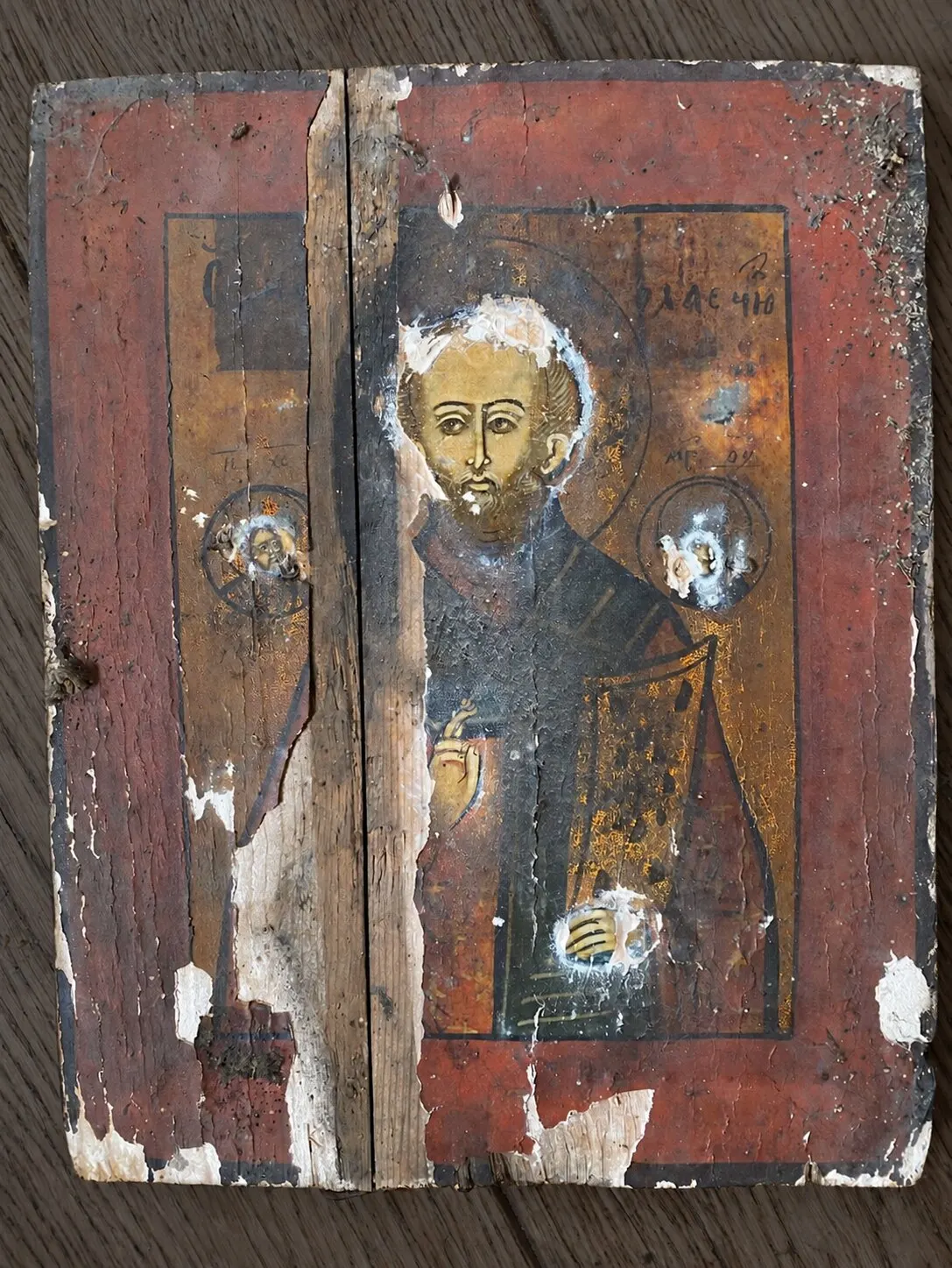 Before restoration. View without the riza: open joint between the boards, losses of ground and paint.