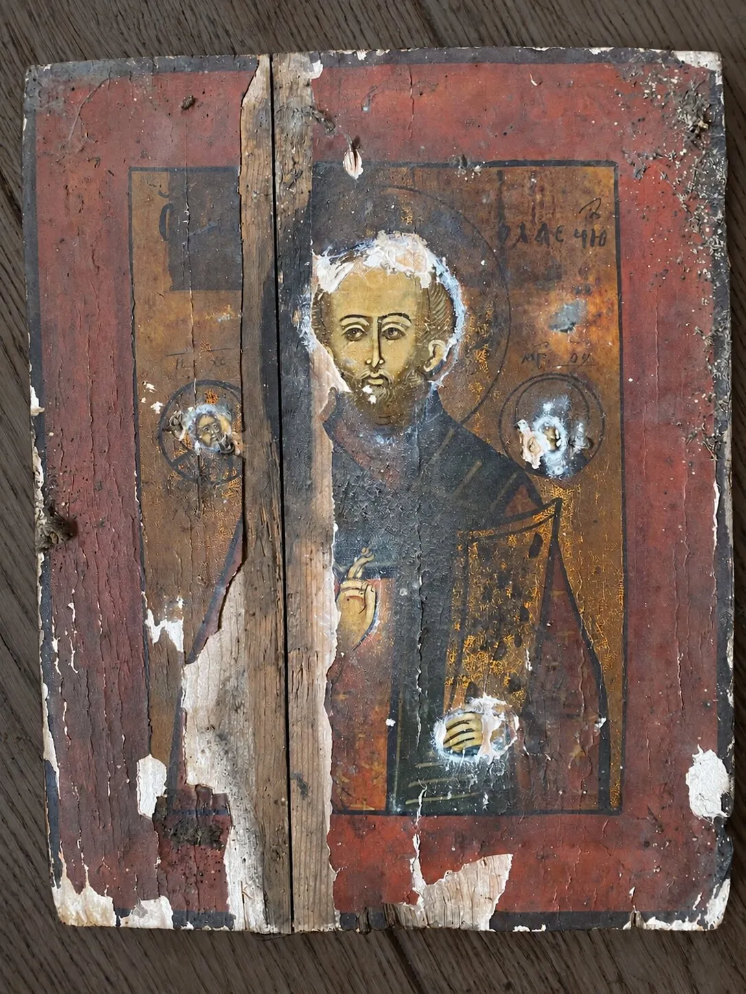Before restoration. View without the riza: open joint between the boards, losses of ground and paint.