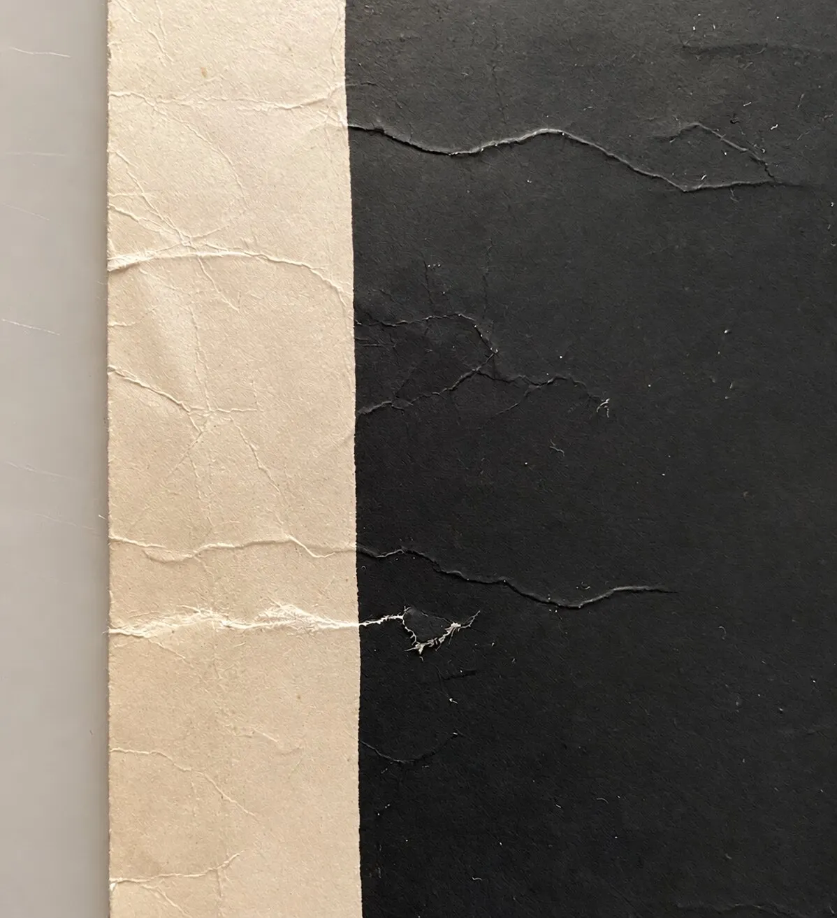 Before restoration. Tears, creases and crumpling of the paper.