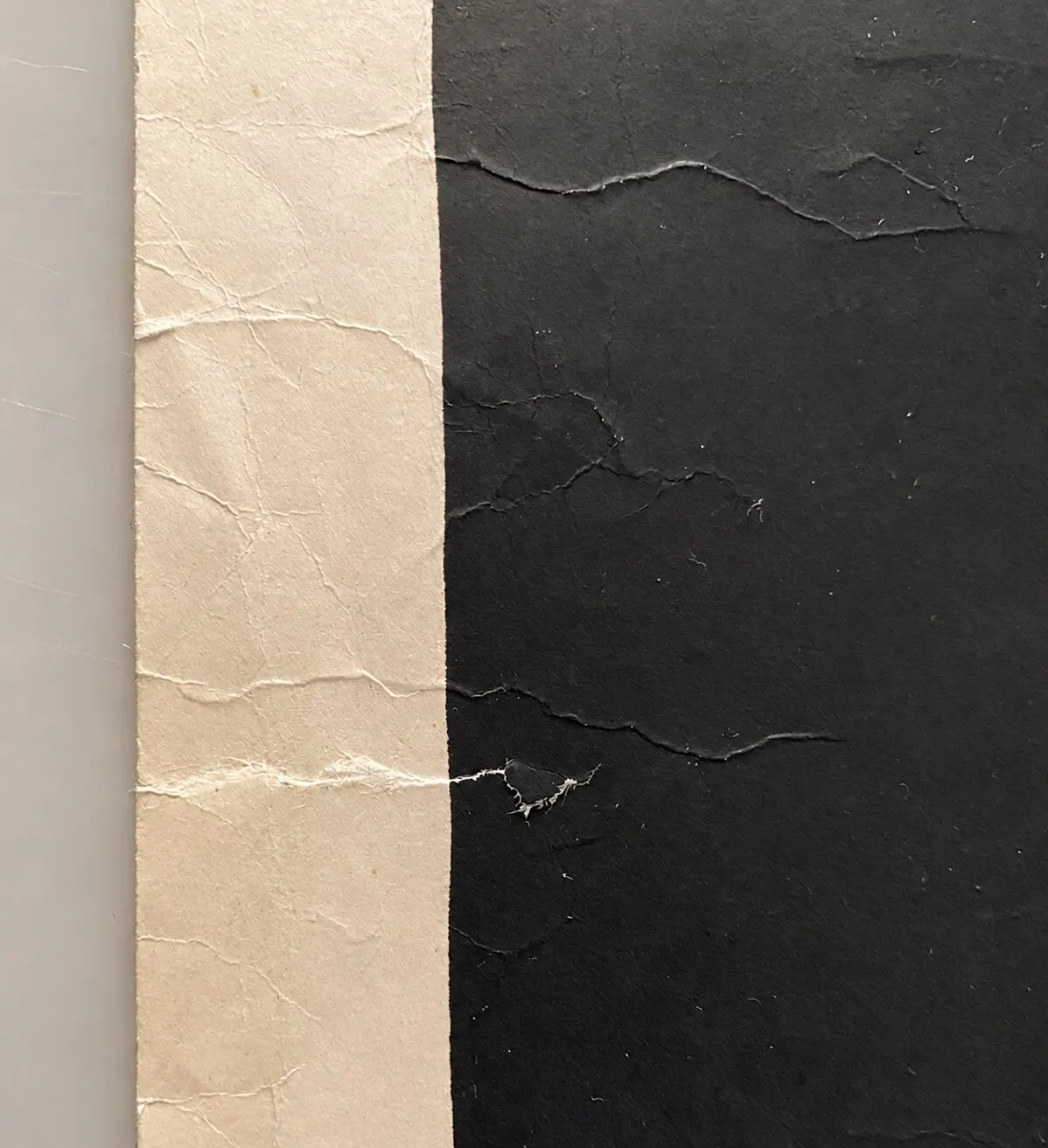 Before restoration. Tears, creases and crumpling of the paper.