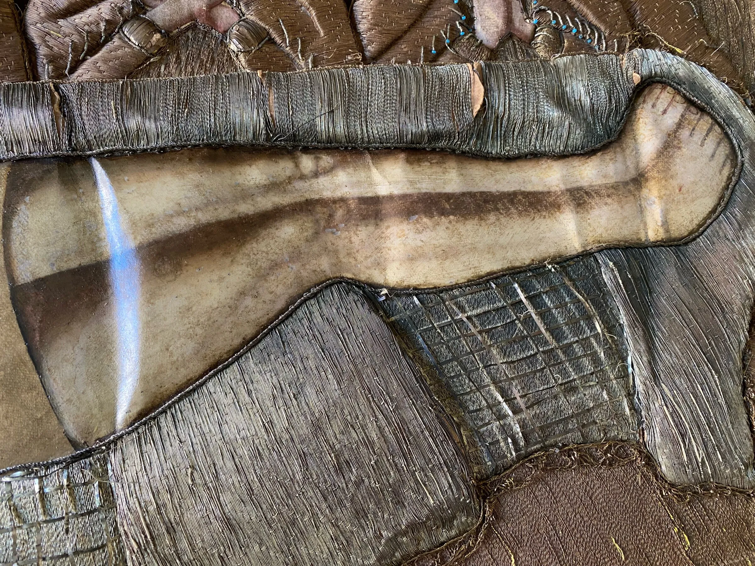 Detail am Übergang zwischen gemaltem Einsatz und Metallstickerei.